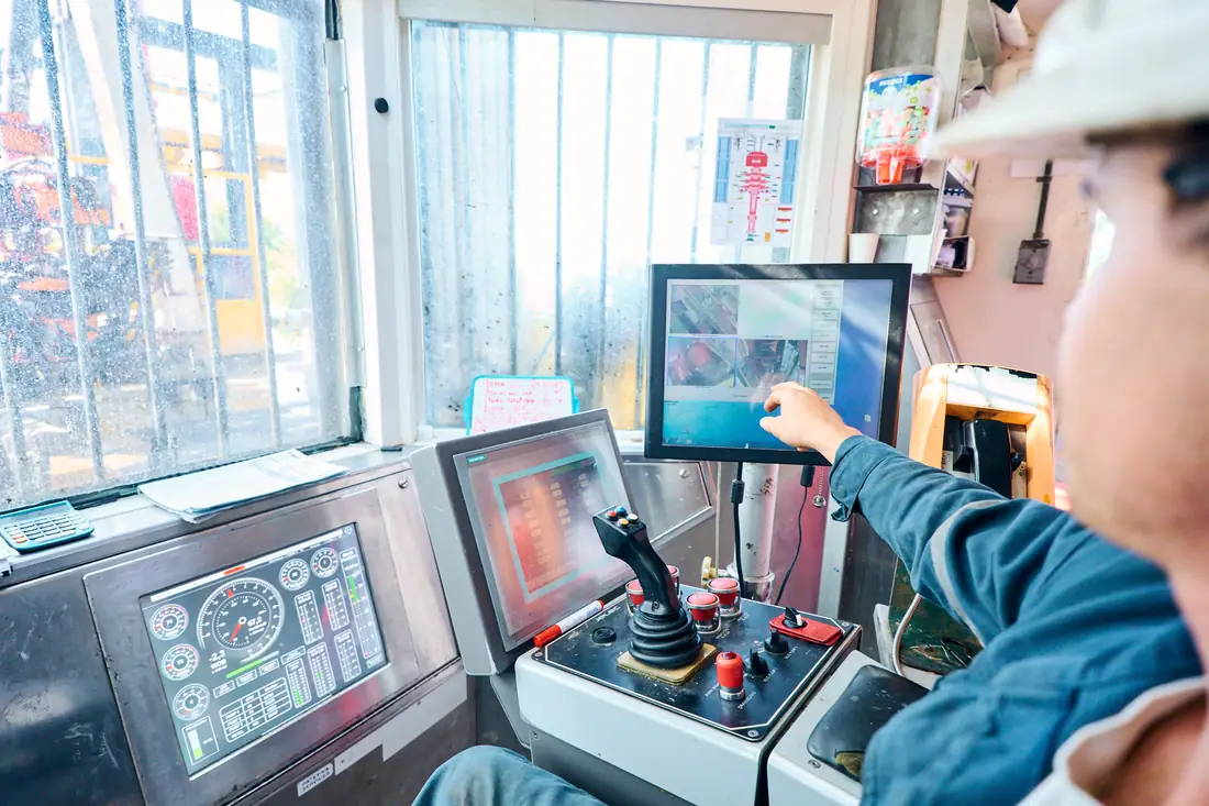 Main du foreur sur l'écran de contrôle dans la cabine de pilotage
