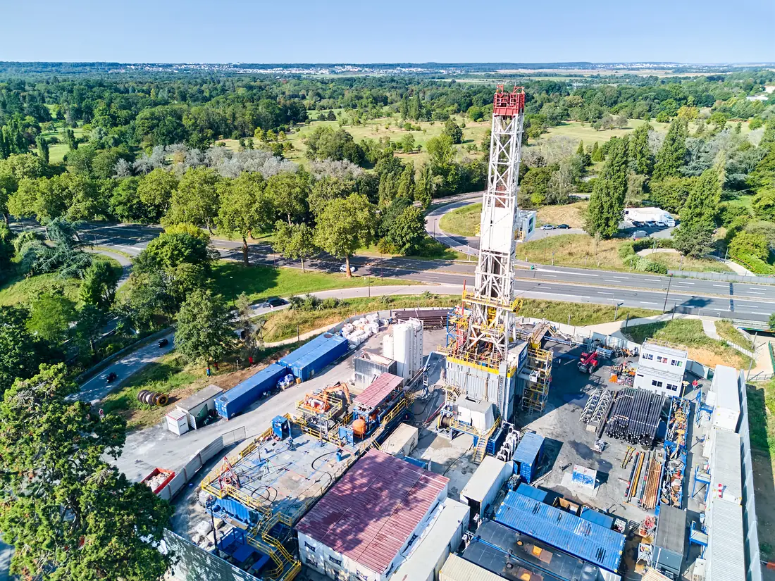 Vue aérienne de la tour de forage géothermique ENGIE au milieu des arbres et des bureaux