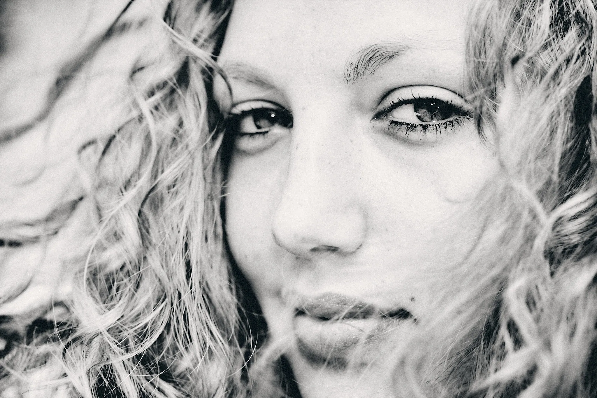 Portrait en noir et blanc d’une femme aux cheveux bouclés